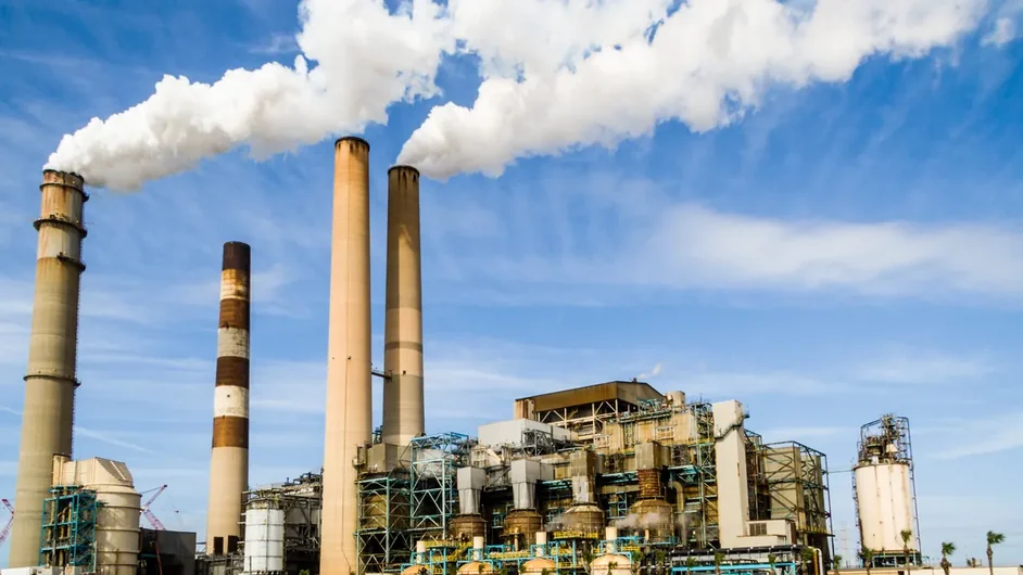 Chaminés industriais liberando vapor sob céu azul