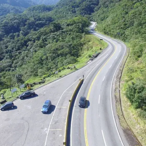 Rodovia sinuosa cercada de mata vista de cima